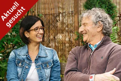 Eine Freiwillige und ein Rotkreuz-Notruf-Kunde lächeln sich an. 