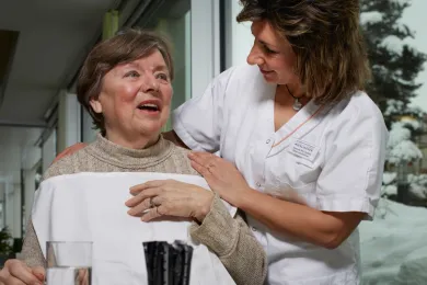 Eine Pflegehelfende SRK unterstützt eine Patientin