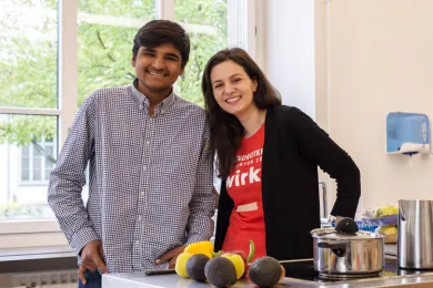 Teilnehmende des First Wednesday Dinner kochen gemeinsam.