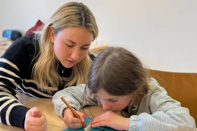 Eine Sprachtreff-Freiwillige mit einem Kind beim Basteln