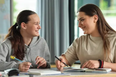 Eine Freiwillige hilft bei den Hausaufgaben