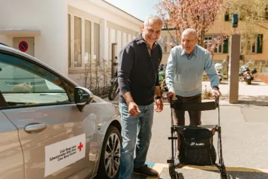 Ein freiwilliger Rotkreuz-Fahrer bringt einen Fahrgast nach Hause