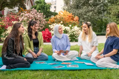 Fünf Frauen sitzen im Park und tauschen sich aus