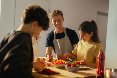 Teilnehmende der Ferienwoche Sport und Kochen bereiten zusammen Spaghetti vor.