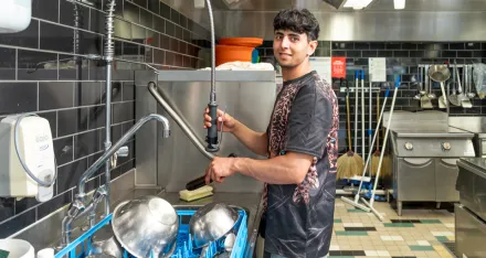 Ein Teilnehmender wäscht Schüsseln ab