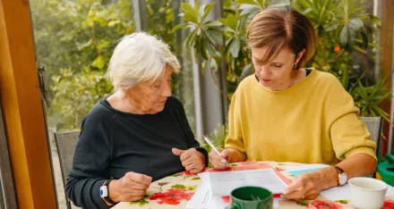 Zwei Frauen füllen am Küchentisch ein Formular aus