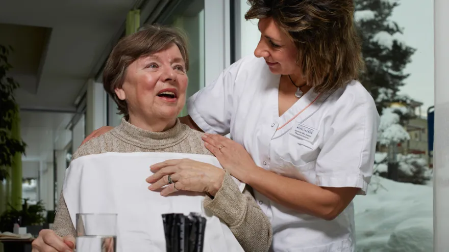 Eine Pflegehelfende SRK unterstützt eine Patientin