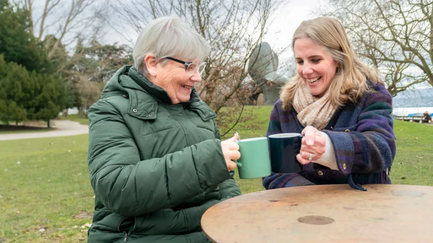 Eine Teilnehmende und eine Freiwillige von Pontesano trinken zusammen in einem Café einen Tee.