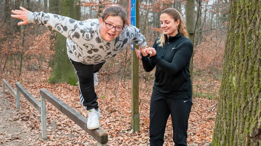 Eine Freiwille des Roten Kreuzes Zürich trainiert mit ihrem Mentee im Wald.