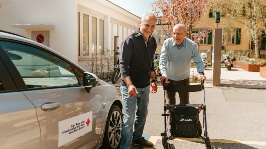 Ein freiwilliger Rotkreuz-Fahrer bringt einen Fahrgast nach Hause