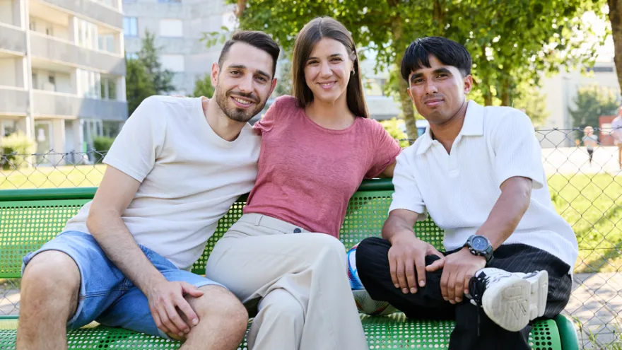 Drei Personen auf einer Sitzbank im Park