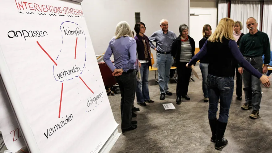 Eine Gruppe steht im Kreis und bespricht etwas.