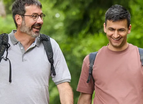 Ein Tandem aus einem Integrationsprogramm spaziert im Wald. 
