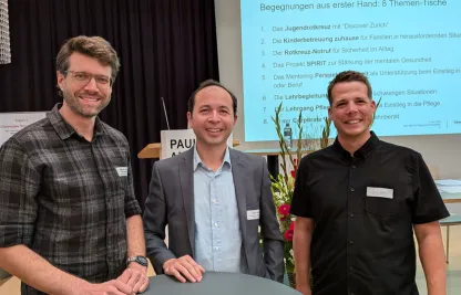 Drei Männer lachen in die Kamera. Zwei von ihnen arbeiten bei Colt und der dritte beim Rotkreuz-Fahrdienst.
